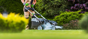 A landscaper mowing a lawn.